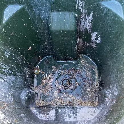 Inside of a green bin before cleaning — grime and residue